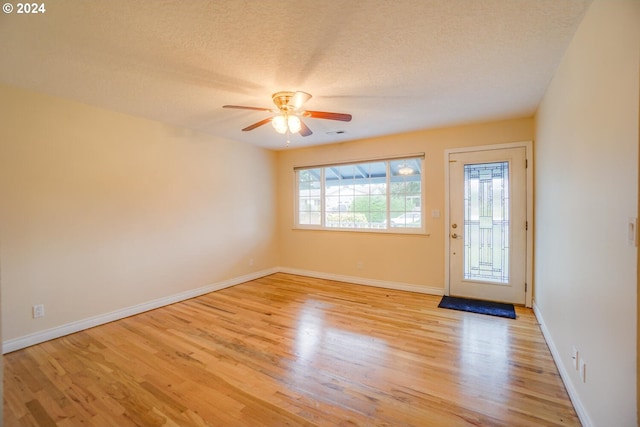 entryway with a textured ceiling, ceiling fan, and light hardwood / wood-style floors