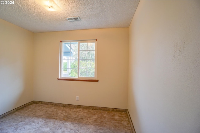 unfurnished room featuring a textured ceiling and carpet flooring