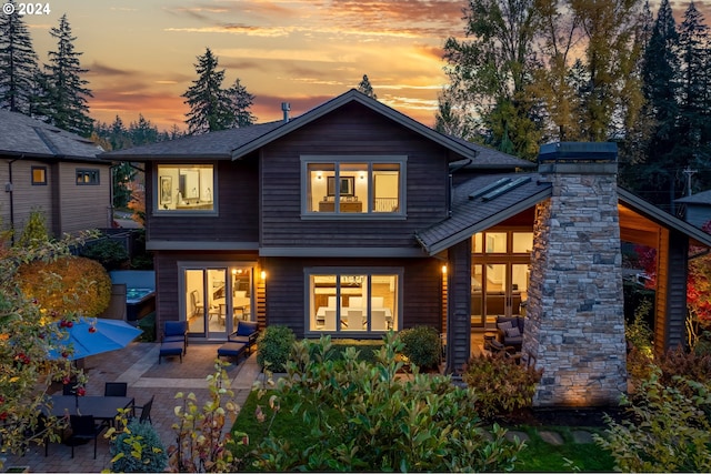 back house at dusk with a patio area