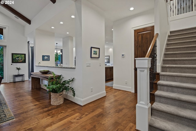 entrance foyer with hardwood / wood-style floors and vaulted ceiling with beams