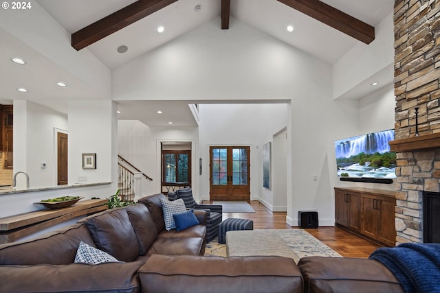 living room with high vaulted ceiling, french doors, a fireplace, beamed ceiling, and dark hardwood / wood-style flooring