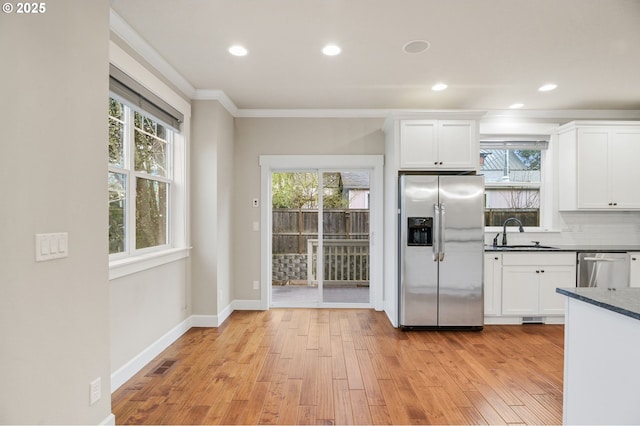kitchen featuring visible vents, a sink, dark countertops, crown molding, and stainless steel appliances