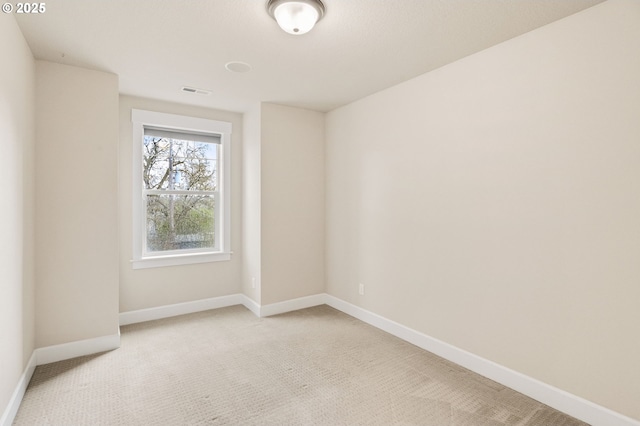 unfurnished room with light carpet, visible vents, and baseboards