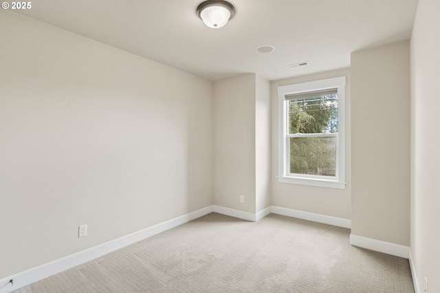 unfurnished room featuring light colored carpet, baseboards, and visible vents