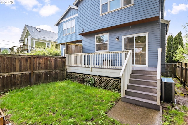back of property featuring central AC unit, a fenced backyard, a wooden deck, and a yard