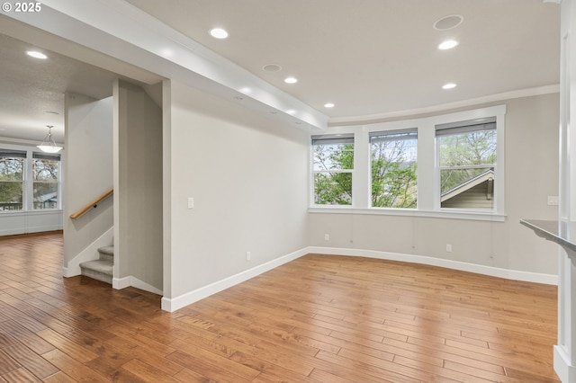 empty room with light wood finished floors, recessed lighting, and stairs