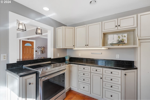 kitchen with recessed lighting, light wood-style floors, stainless steel electric range, open shelves, and dark stone countertops