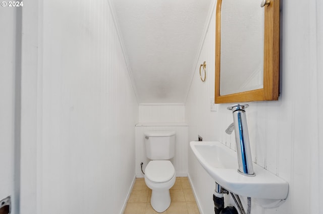 bathroom with tile patterned floors, toilet, ornamental molding, and a textured ceiling