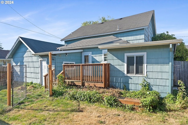 back of house with fence and a deck