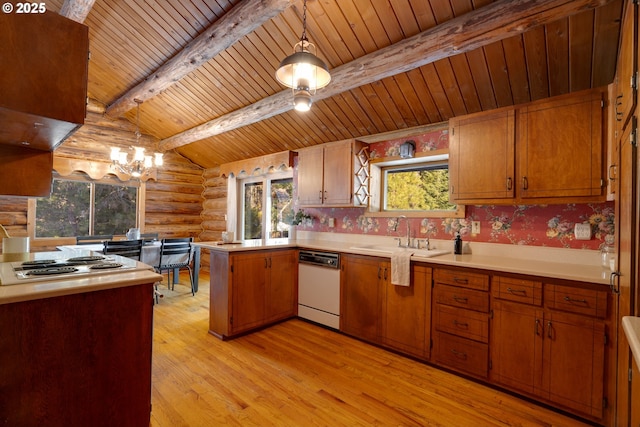 kitchen featuring light wood-type flooring, dishwasher, hanging light fixtures, rustic walls, and sink