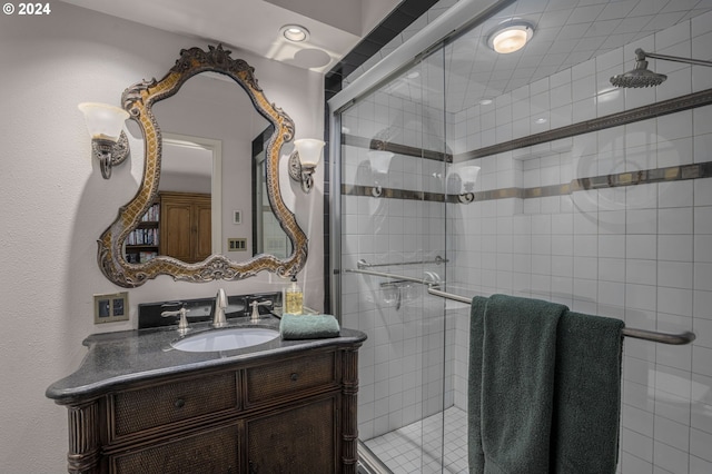 bathroom featuring a shower with door and vanity