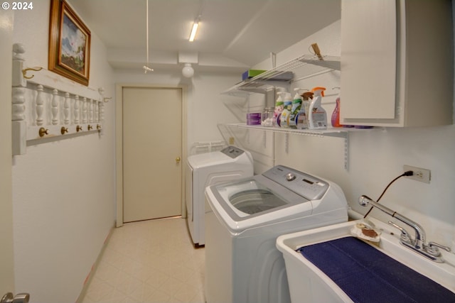 laundry area featuring a sink, washer and clothes dryer, and light floors