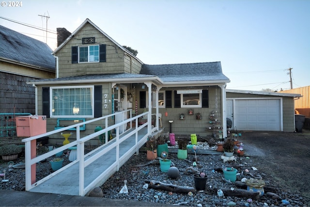 view of front facade featuring driveway, a porch, and roof with shingles