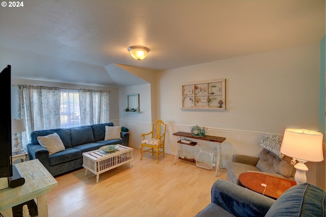 living area featuring wood finished floors and wainscoting