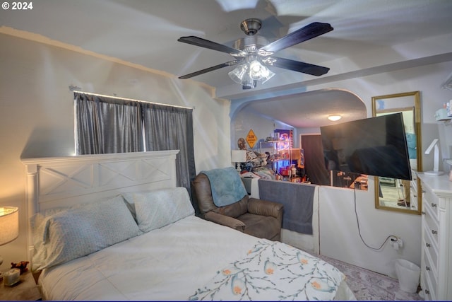 bedroom featuring a ceiling fan and beamed ceiling