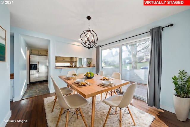 dining room with hardwood / wood-style floors and an inviting chandelier