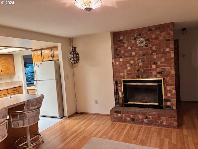 living room with a fireplace and light wood-type flooring