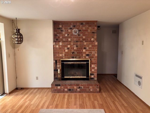 unfurnished living room featuring a fireplace and light hardwood / wood-style floors