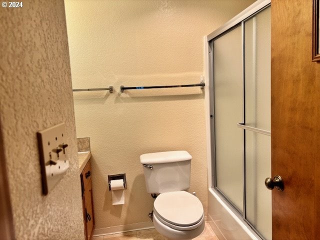 bathroom featuring tile patterned flooring, toilet, and enclosed tub / shower combo