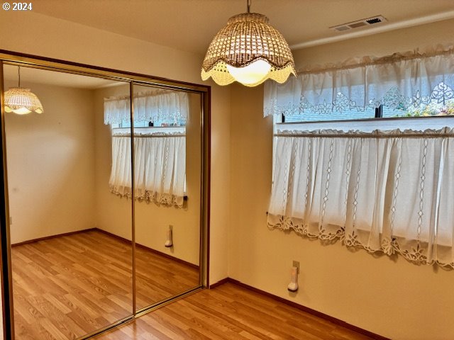 unfurnished bedroom with hardwood / wood-style flooring and a closet