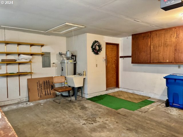 interior space featuring strapped water heater, sink, and electric panel