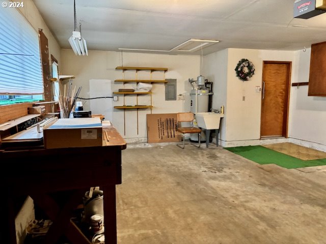 interior space with secured water heater, electric panel, sink, and concrete flooring