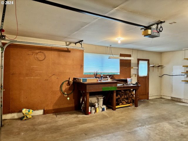 garage with a workshop area and a garage door opener