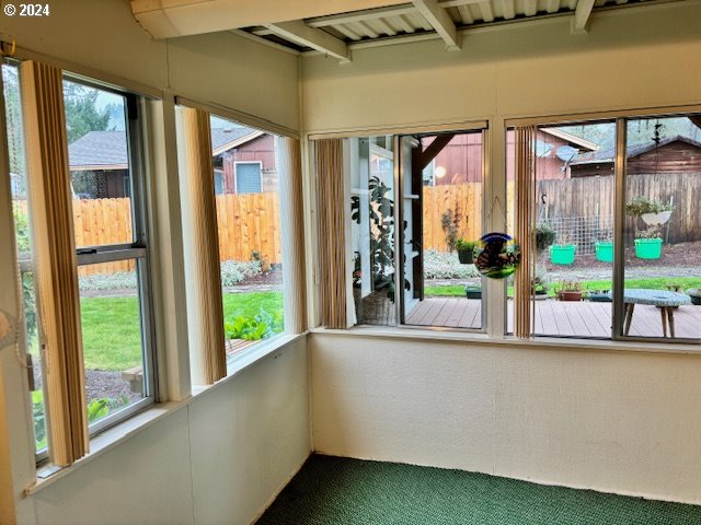 unfurnished sunroom featuring plenty of natural light and beam ceiling