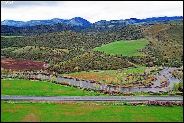 drone / aerial view with a water and mountain view