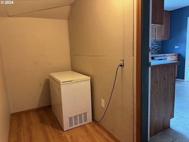 clothes washing area featuring light hardwood / wood-style flooring