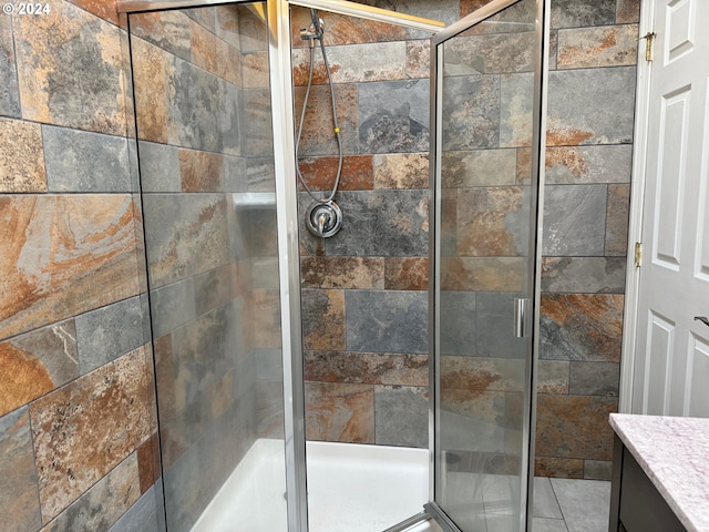 interior space with tile patterned flooring, vanity, and a shower with shower door