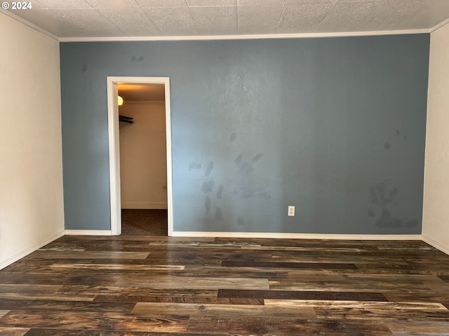 spare room with ornamental molding and dark hardwood / wood-style floors