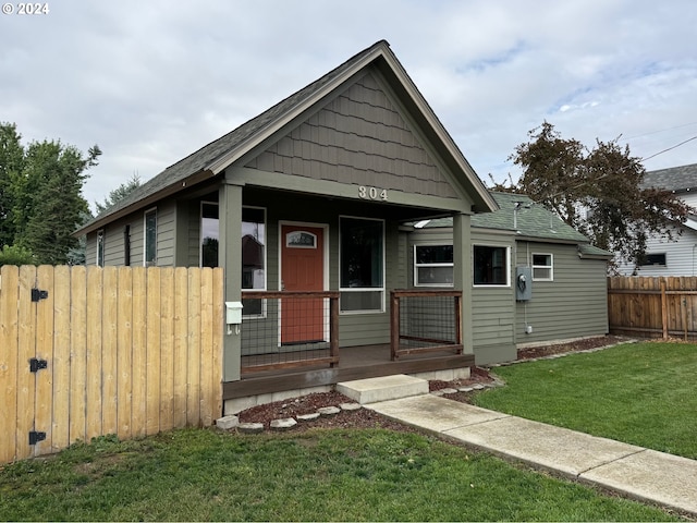 bungalow with a porch and a front lawn