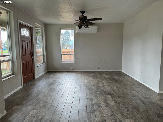 foyer entrance featuring ceiling fan, a wall mounted air conditioner, a healthy amount of sunlight, and dark hardwood / wood-style flooring