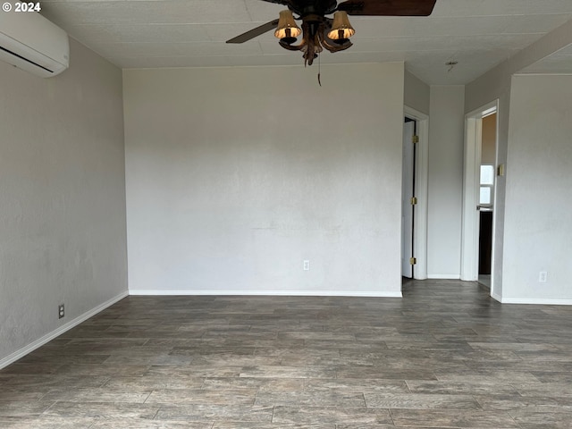 empty room with a wall unit AC, ceiling fan, and dark wood-type flooring