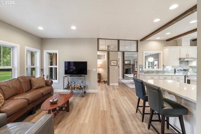 living room with beamed ceiling and light hardwood / wood-style flooring