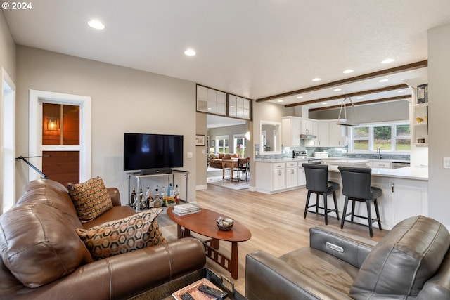 living room with beam ceiling and light hardwood / wood-style flooring