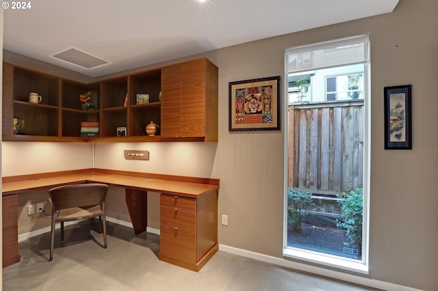 office with built in study area, baseboards, and visible vents