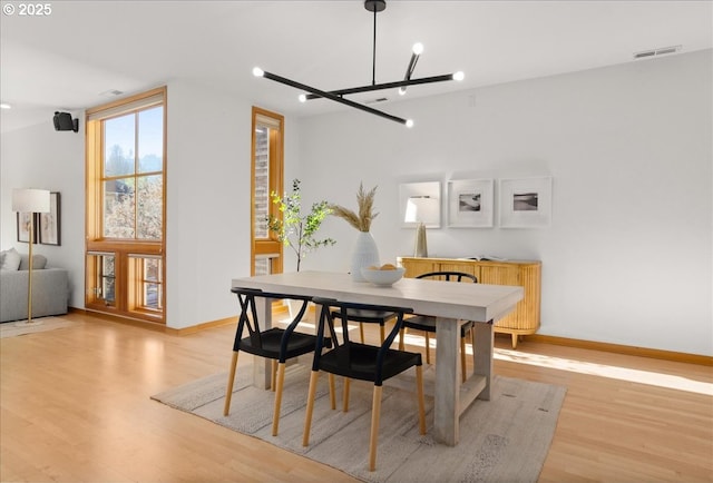 dining area featuring an inviting chandelier and light hardwood / wood-style flooring