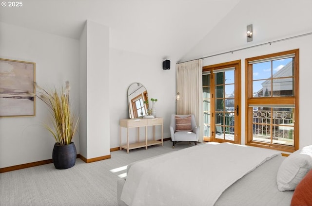 carpeted bedroom featuring multiple windows, lofted ceiling, and access to outside