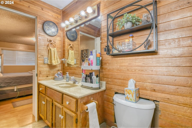 bathroom with wood walls, vanity, wood-type flooring, and toilet