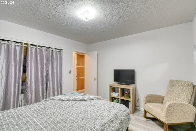 bedroom featuring wood-type flooring and a textured ceiling