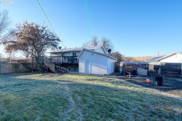 rear view of house with a lawn and a wooden deck