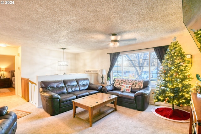 living room featuring light carpet, ceiling fan, and a textured ceiling