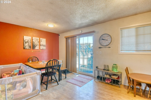 dining area with light wood-type flooring and a textured ceiling