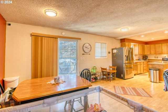 dining room with light hardwood / wood-style flooring and a textured ceiling