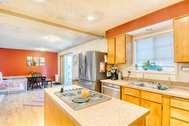 kitchen with sink, stainless steel appliances, a textured ceiling, and light wood-type flooring