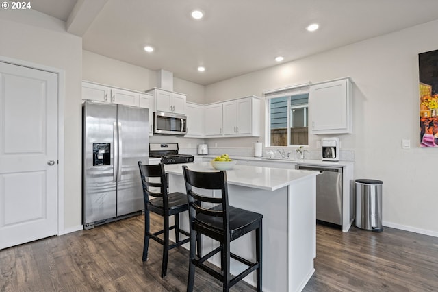 kitchen featuring a center island, stainless steel appliances, dark hardwood / wood-style floors, and white cabinetry