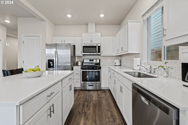 kitchen featuring dark wood-type flooring, a kitchen island, stainless steel appliances, and sink