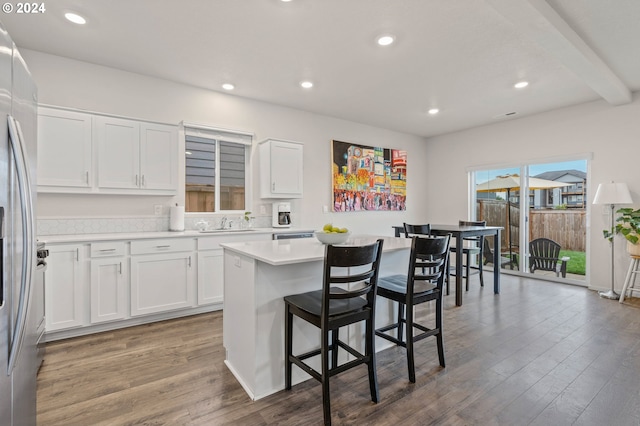 kitchen featuring a kitchen island, stainless steel refrigerator with ice dispenser, dark hardwood / wood-style flooring, and white cabinets